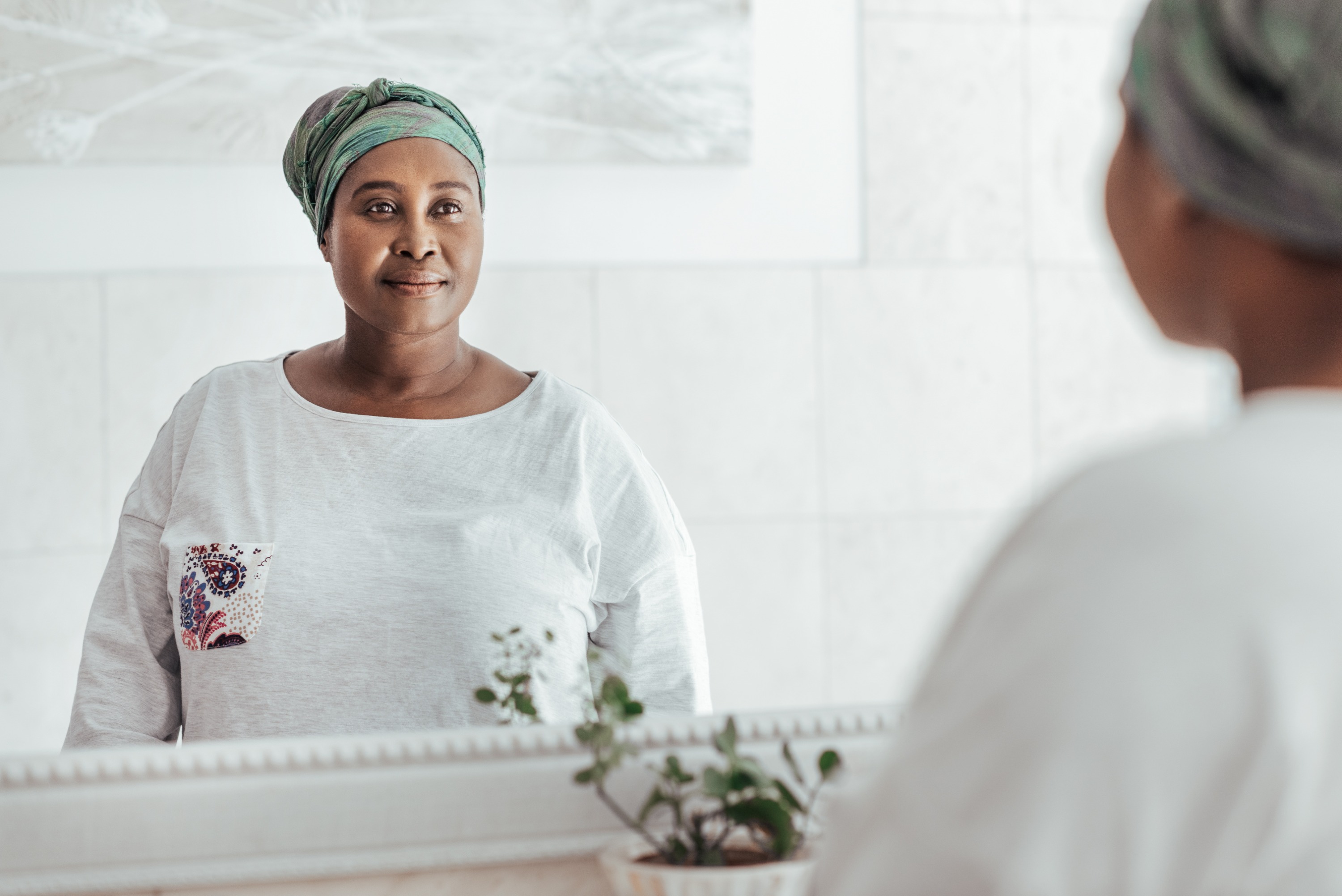 Black woman looking at herself in the mirror